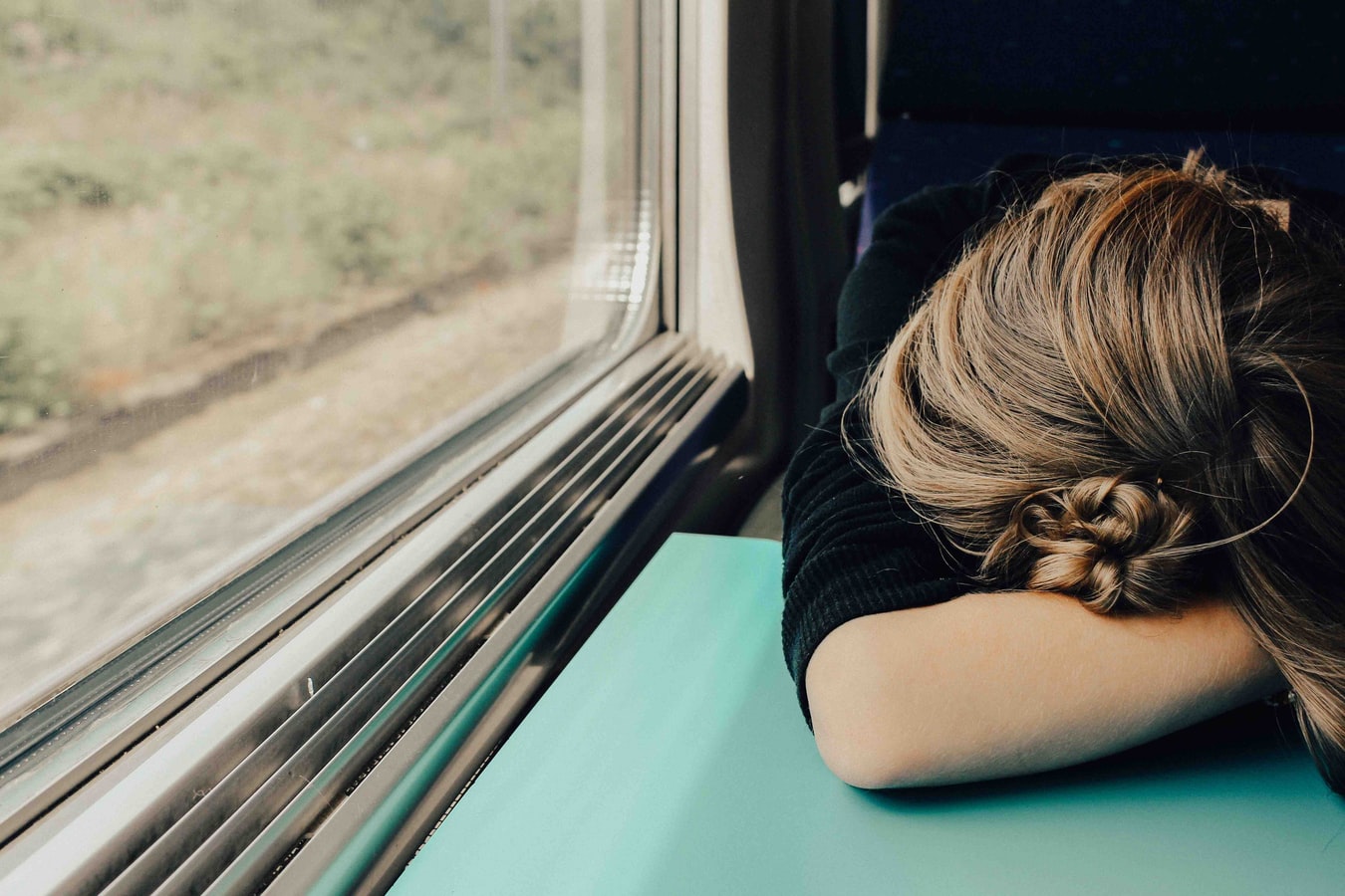 Woman asleep on train during daytime